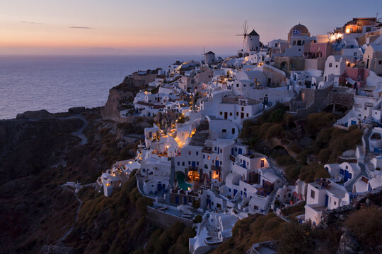 Greece, Cyclades, Thira, Santorini, View of Oia and windmills after sunset