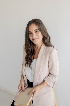 Confident businesswoman holds a notebook and pen indoors