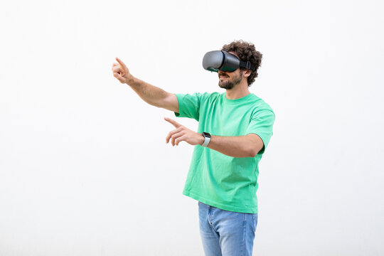 Man in green shirt interacts with virtual reality headset indoors