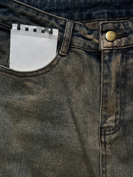 Ripped torn paper blank note mockup in  jeans clothes pocket with a textured denim. Retro minimalist aesthetic background for diy collages.