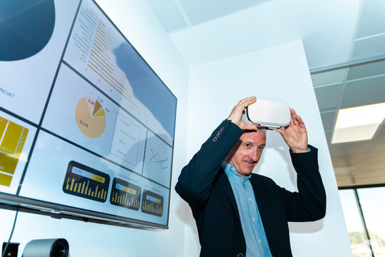 Businessman removes virtual reality headset in the office