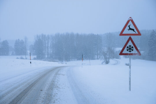 Germany, Bavaria, Moerlbach, View of country road covered in snow with sign board