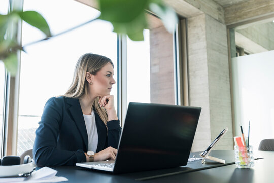 Young businesswoman working with laptop at desk in office
