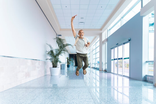 Excited male traveler celebrates his journey in the airport