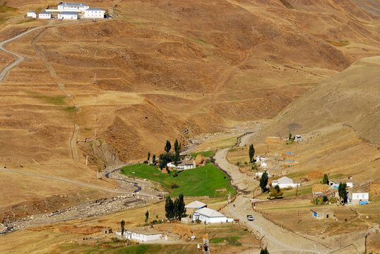 Azerbaijan, Xinaliq, elevated view of village in dry landscape and mountain range