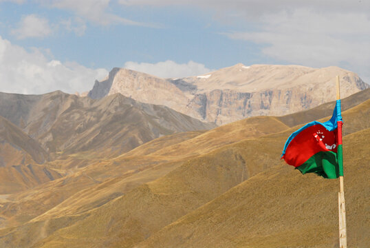 Azerbaijan, Xinaliq, view of azeri flag along with mountain range against cloudy sky
