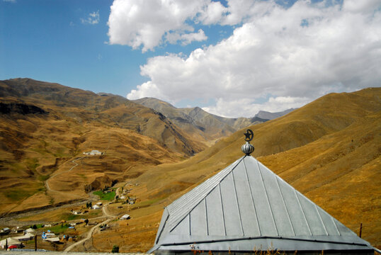 Azerbaijan, Xinaliq, view of mosque along with landscape and mountain ranges against cloudy sky