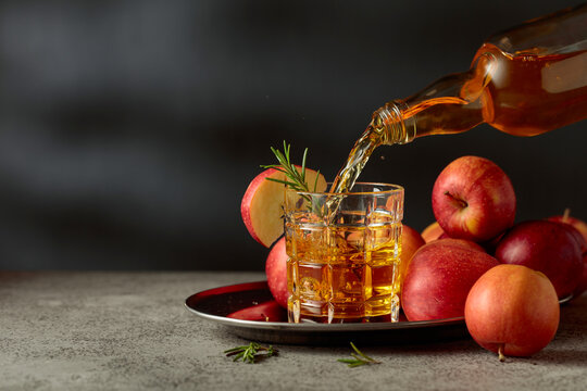 Apple juice is poured from a bottle into a glass.
