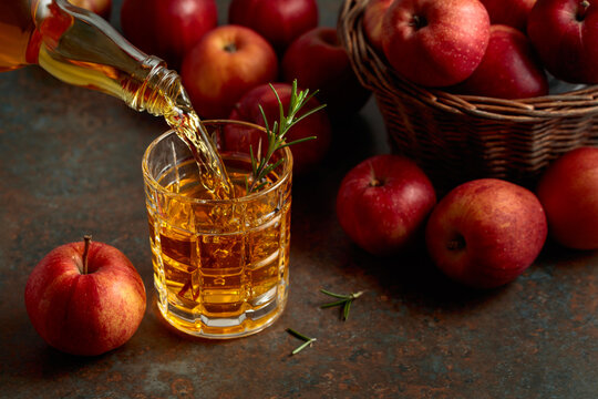 Apple juice is poured from a bottle into a glass.