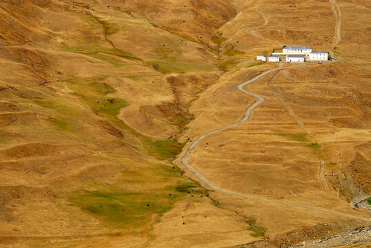 Azerbaijan, Xinaliq, view of dry hilly landscape amid isolated industry and house