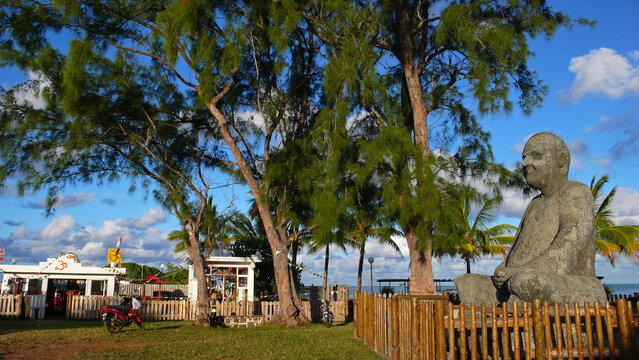 Mauritius, Mahebourg, wooden railings around concrete statue of a deity sitting in lotus position