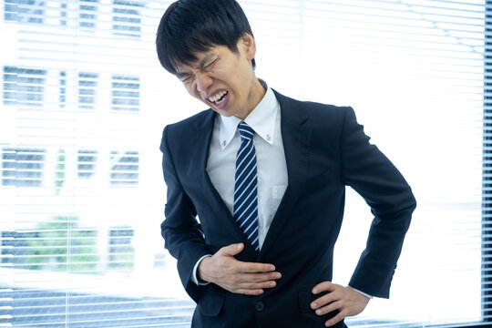 オフィスで腹痛に苦しむビジネスマン