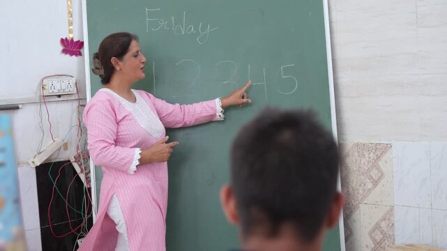 Indian female teacher helping students learn basic mathematics in an inclusive classroom, providing personalized support to children with special educational needs