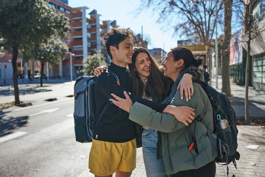 Group of young athletes giving hug during a friendly sports session on the waterfront