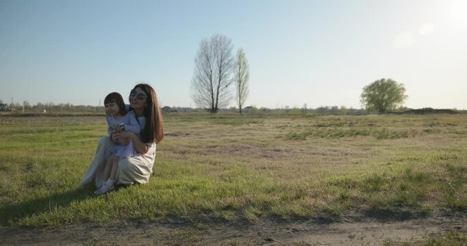 Young mother with child daughter spend time playing enjoying nature. 4K 10-bit