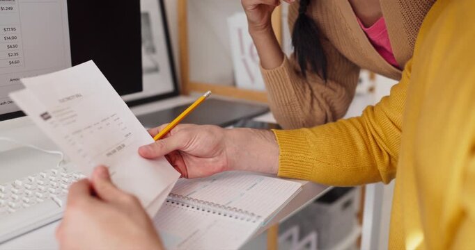 Couple planning expenses online with computer bill. They review a utility invoice, note figures in a planner, and discuss payment options to cut costs. Basic home budget plan concept.
