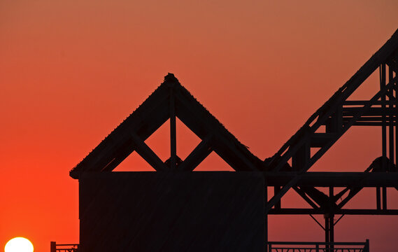Madagascar, Morondava, Kimoni, sunset on wooden abandonned structure by the beach