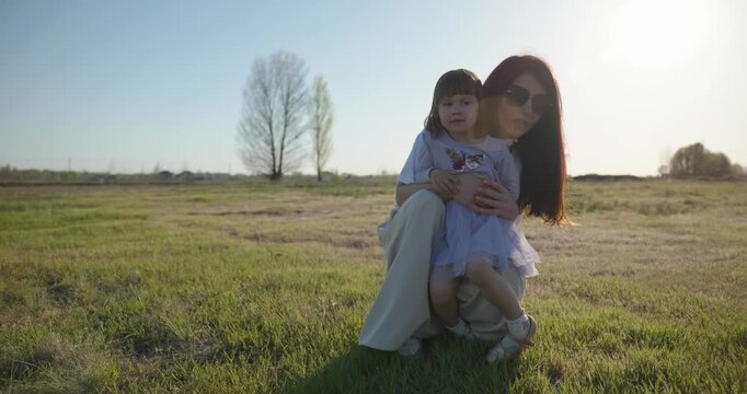 Young mother with child daughter spend time playing enjoying nature. 4K 10-bit