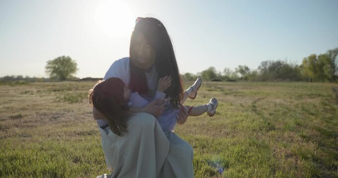 Young mother with child daughter spend time playing enjoying nature. 4K 10-bit