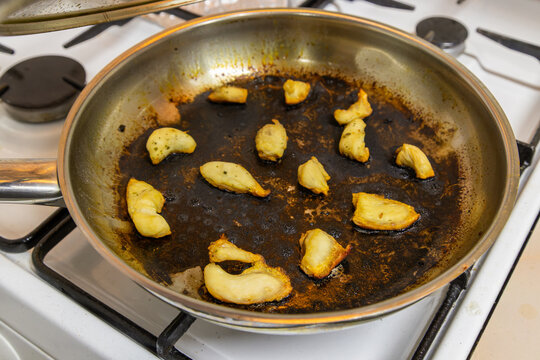 Fried Chicken in Burnt Frying Pan on Gas Stove
