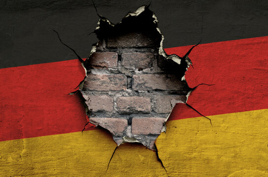 national flag of Germany is painted on an old wall with cracks