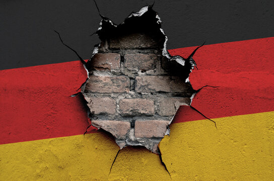 national flag of Germany is painted on an old wall with cracks