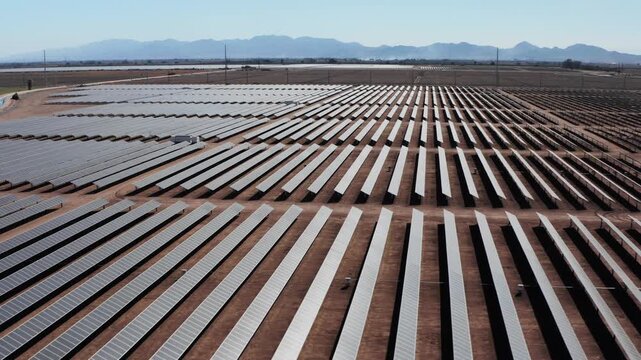 Vast Desert Solar Farm and Mountain Range Tilt-Up Reveal - Drone Aerial Shot - 4K UHD