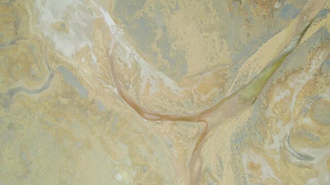 Aerial View Of Braided River Channels And Dry Riverbed Patterns Across Arid Outback Terrain, Drone Shot