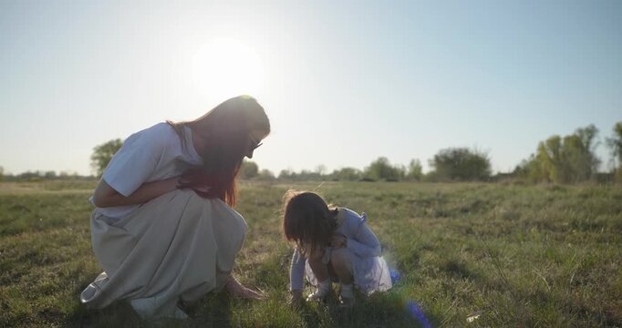 Young mother with child daughter spend time playing enjoying nature. 4K 10-bit