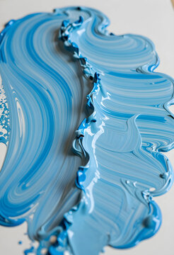 Blue paint strokes and swirls creating a textured background with Varying shades of color, Varying shades of blue paint are mixed together, forming a fluid and artistic pattern
