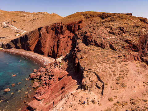 Drone view of dramatic red volcanic rock formations and coast at Red Beach Santorini island Greece