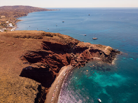 High aerial drone panorama of Red Beach coastline and turquoise Aegean Sea in Santorini Greece