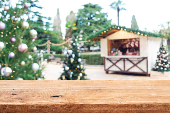 Empty wooden table top for your design on blurred Christmas market background in tropical winter holidays