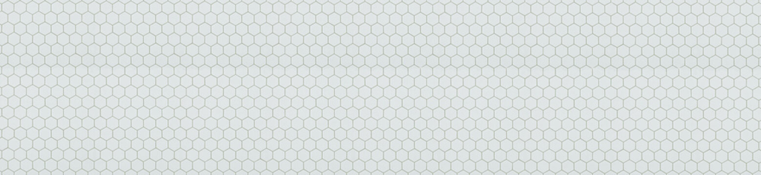 Small white hexagonal ceramic mosaic tiles with light grey grout lines in honeycomb pattern.