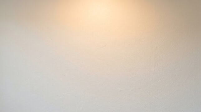 A plain light-colored wall illuminated by a warm glow from above, creating a soft background.