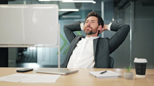 Professional finds peace after completing tasks. Relaxes at office desk. Experience success and satisfaction from achievements. Moment of calm amidst demanding business environment.
