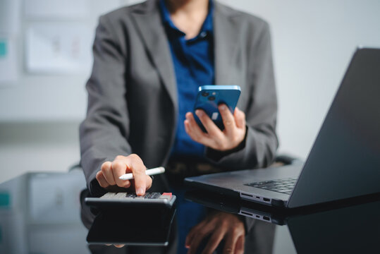 Close up of businesswoman or accountant hand typing laptop working to calculate on desk about cost at home office.