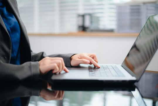 Businesswoman hands typing on smartphone and laptop keyboard in morning light computer, typing, online in office