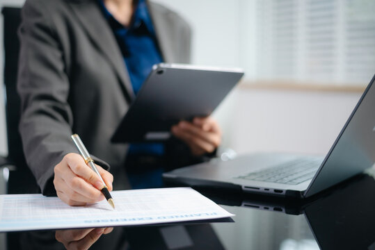 business documents on office desk with laptop and smart phone and graph business diagram and man working in morning light