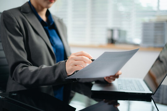 Close-up view of young professional businesswoman writing his idea concepts on notebook while working on his project at office