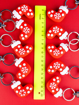 A set of 10 Christmas stocking gift keychains in a close-up view. Each mini sock features festive colors and glossy details, sparkling highlights on a red background.