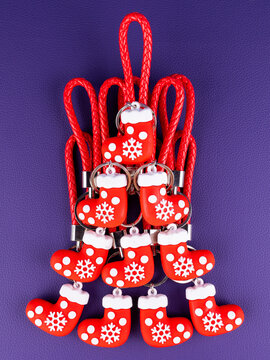 A set of 10 Christmas stocking gift keychains in a close-up view. Each mini sock features festive colors and glossy details, sparkling highlights on a purple background.