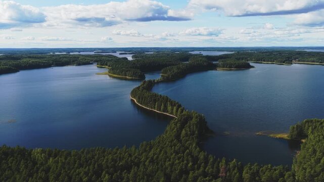 Aerial view of the scenic Punkaharju ridge surrounded by deep blue lakes and dense pine forests in Savonlinna, South Savo, Finland.