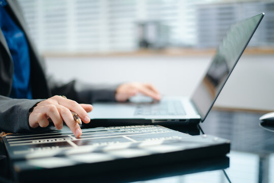 Creative filmmaker planning a video production project with a clapperboard, laptop and smartphone, representing filmmaking, content creation, media and digital storytelling.