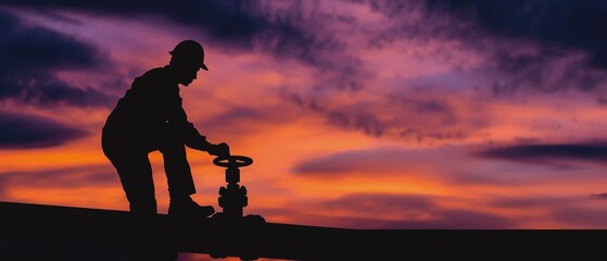 Fototapeta premium Worker managing valve at sunset sky.