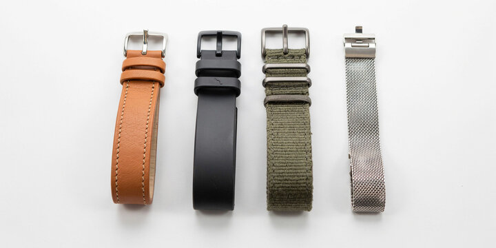 Four different watch straps including leather, rubber, fabric, and metal mesh bands