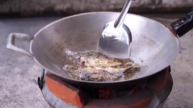 Traditional Thai cooking over charcoal, featuring spicy deep-fried fish and authentic local cuisine.