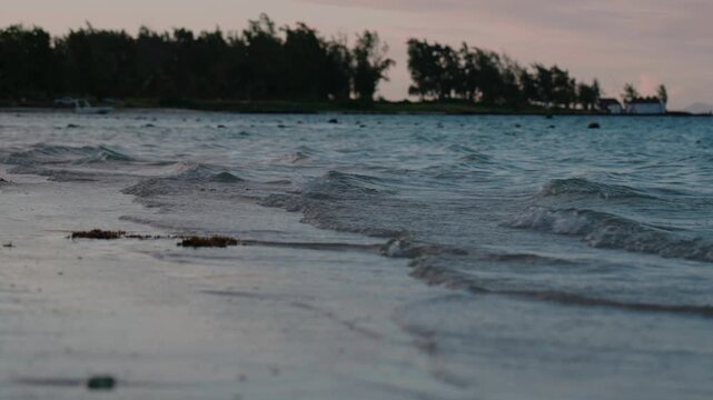 Waves crashing in slow motion on Belle Mare beach in Mauritius, after sunset