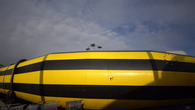Frederikshavn, Denmark A parked yellow and black concrete truck spins in a parking lot. 