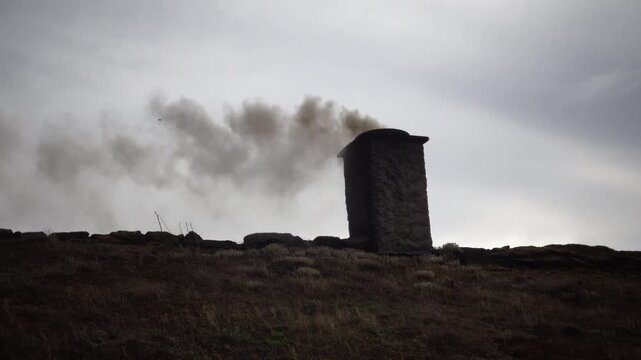 Laeso, Denmark A wood burning chimney on a thatched roof with smoke used to make salt in the salt flats.  